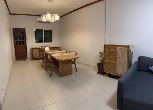 Kathu Home with Mountain View في كاتو: غرفة طعام مع طاولة وأريكة زرقاء
