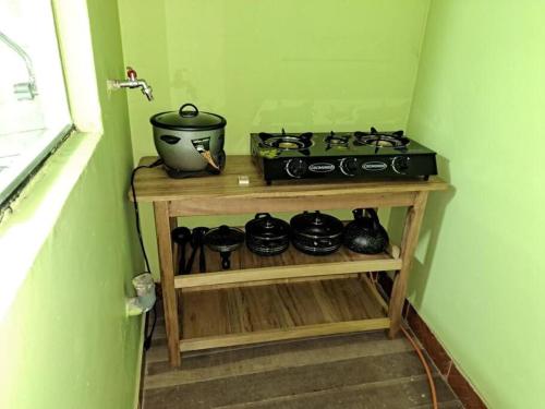 a kitchen with a stove and pots on a shelf at Julio Reyna Apartamento in Cusco