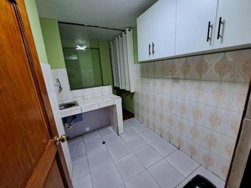 a bathroom with a sink and a mirror at Julio Reyna Apartamento in Cusco