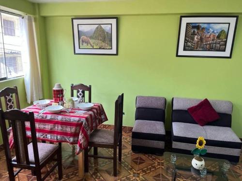 una sala da pranzo con tavolo e sedie in una stanza di Julio Reyna Apartamento a Cuzco