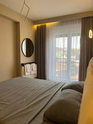 een slaapkamer met een groot bed en een raam bij TOP-Apartments in Pristina