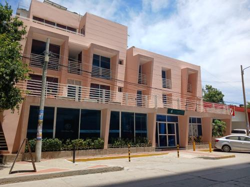 a pink building with a balcony on a street at Hotel Bahia Plaza in Santa Marta