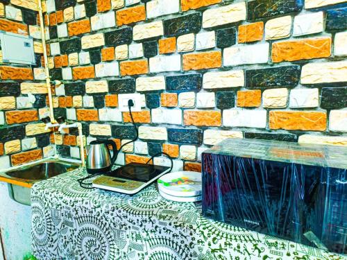 a table in front of a brick wall at Sahara Family Homestay in Mysore
