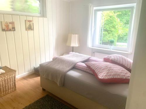 a bedroom with a bed with pillows and a window at FeWo Bea - Stadtzentrum und Ostseenähe in Bad Schwartau