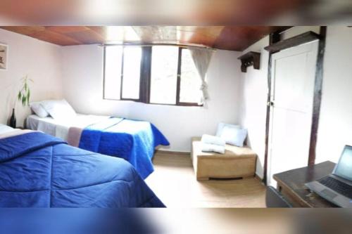 1 dormitorio con 2 camas y ordenador portátil. en Hospedaje Dulce Piedad, en Ambato