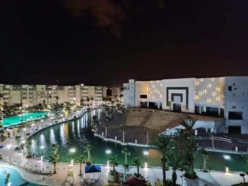a view of a resort at night with a pool at Super appartement avec 5 piscines en résidence in Monastir