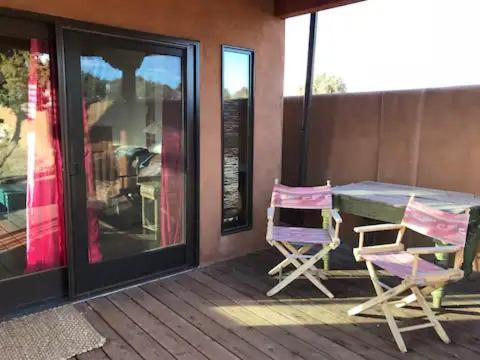 eine Terrasse mit einem Tisch und 2 Stühlen auf einer Veranda in der Unterkunft Casita Luna in Santa Fe