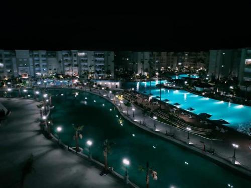 Blick auf einen großen Pool in der Nacht in der Unterkunft Super appartement avec 5 piscines en résidence in Monastir
