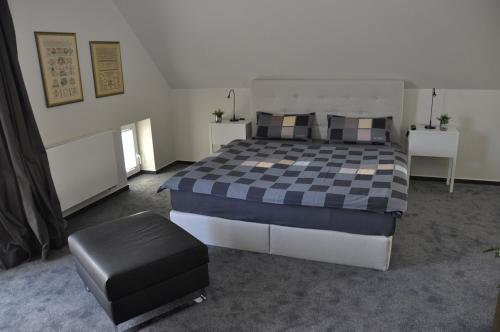 - une chambre avec un grand lit et une couverture en damier dans l'établissement Aquarell, à Schönberger Strand