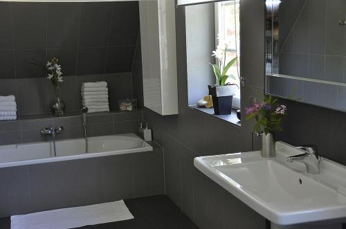 La salle de bains est pourvue d'une baignoire, d'un lavabo et d'un miroir. dans l'établissement Aquarell, à Schönberger Strand