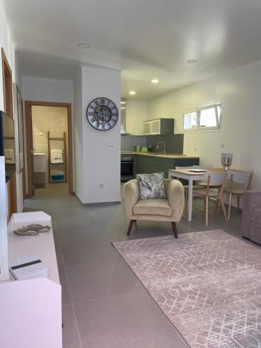 a living room with a chair and a clock on a wall at THE ORANGE TREE HOUSES - Frente by Live and Stay in Abrantes