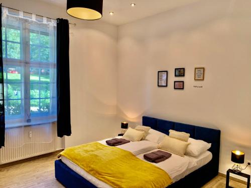 una camera da letto con un letto con una coperta gialla sopra di Luxspace Apartment Hagen a Hagen