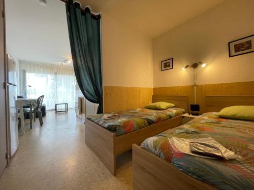 une chambre d'hôtel avec deux lits et une salle à manger dans l'établissement Studio Balaruc-les-Bains, 1 pièce, 2 personnes - FR-1-503-168, à Balaruc-les-Bains