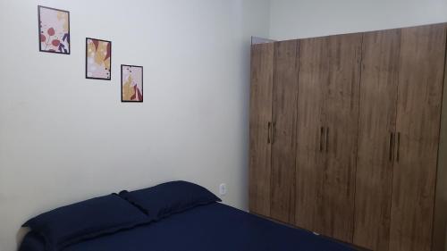 une chambre avec un lit et une armoire en bois dans l'établissement Apto com Varanda no N Bandeirante , proximo ao Aeroporto, à Brasilia