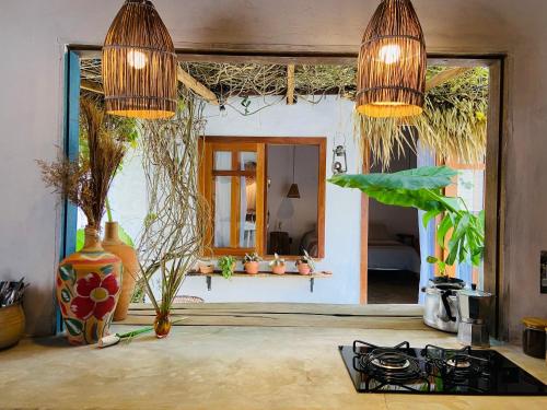 uma cozinha com duas luzes suspensas e um fogão em Quintal da Cuiarana - 50M da praia principal de Alter do Chão em Alter do Chão