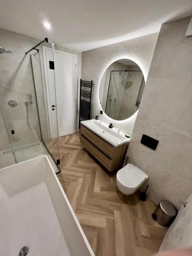 a bathroom with a sink toilet and a mirror at The Penthouse Sarajevo in Sarajevo