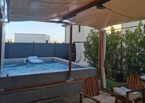 a hot tub on a patio with two chairs at Chambre d'hôte in Grabels