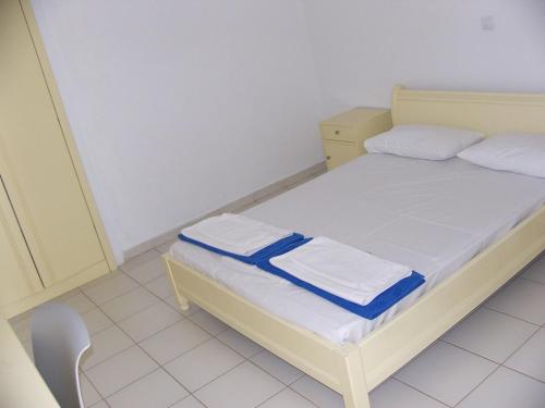 a small bedroom with a bed and a chair at Blue Beach Villas Apartments in Stavros