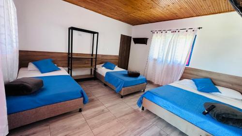 1 Schlafzimmer mit 2 Betten und einem Spiegel in der Unterkunft Finca Hotel MAGIA CAFETERA in Quimbaya