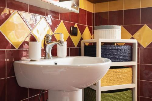 ein Badezimmer mit einem Waschbecken und einem Regal mit Handtüchern in der Unterkunft Relax Sicily House in Savoca 