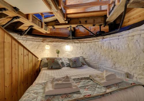 Cama grande en habitación con techo de madera en Red Mill, en Haddiscoe