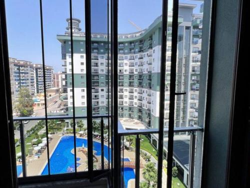 een raam met uitzicht op een groot gebouw bij One-bedroom apartment at Serenity Autumn promotion in Alanya