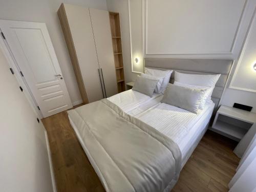 a bedroom with a large bed with white sheets and pillows at Central Apartments Sarajevo in Sarajevo