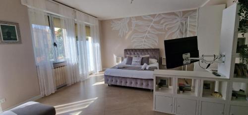 una camera con letto e TV a parete di Kisses From Livorno Open space a pochi passi dal Lungomare a Livorno