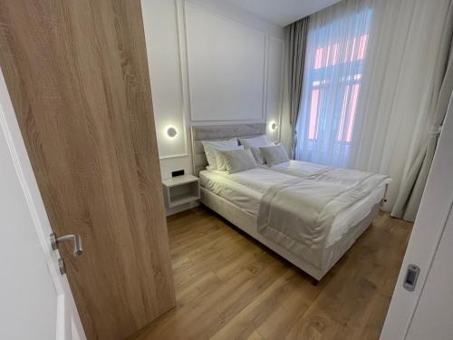 a bedroom with a bed and a large window at Central Apartments Sarajevo in Sarajevo