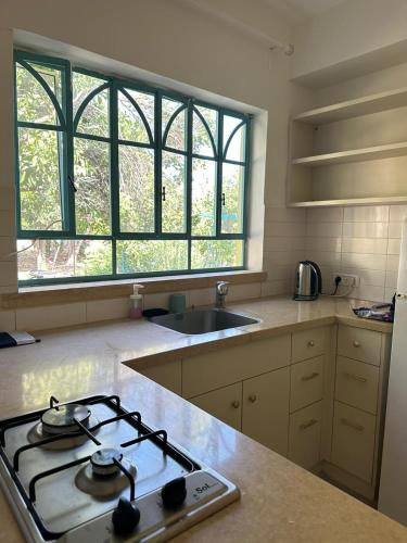 a kitchen with a stove top oven next to a window at רגע מושלם in Shave Ẕiyyon