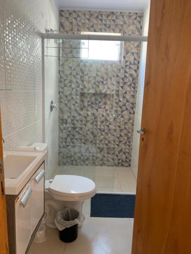 a bathroom with a shower and a toilet and a sink at Canto Gira Sol - Estúdio Sol - Térreo in Penha