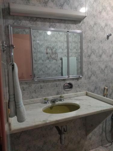 a bathroom with a sink and a mirror at Pousada Samambaia SL in São Lourenço