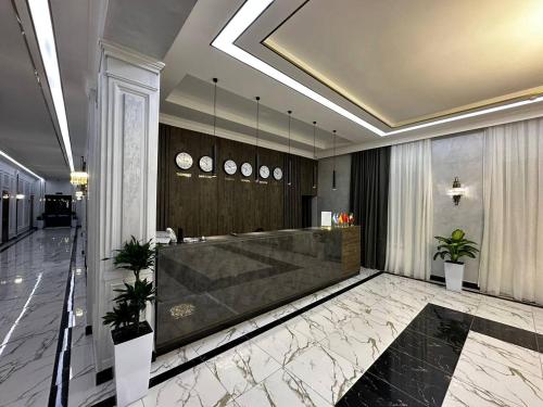 a lobby with a reception desk in a building at Royal Plaza in Qarshi