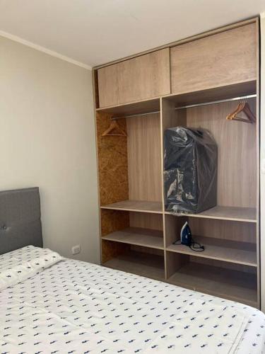 a bedroom with a bed and a closet with shelves at Casa Apartament Paseo Del Mar in Chimbote