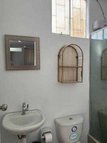 y baño con lavabo, aseo y espejo. en Casa Apartament Paseo Del Mar, en Chimbote