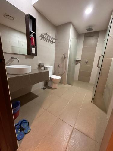 a bathroom with a toilet and a sink and a shower at Sweet Studio Apartment in Kota Bharu