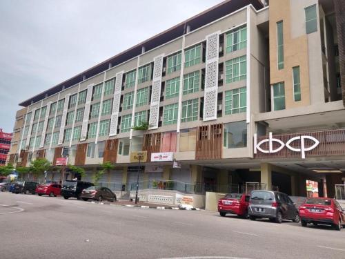 a large building with cars parked in front of it at Sweet Studio Apartment in Kota Bharu