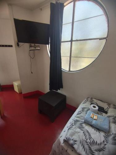 1 dormitorio con cama y ventana redonda en Hotel Casa Sol, en Ica