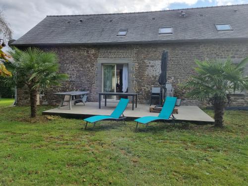 a patio with two chairs and a table in front of a house at Chambre vu campagne in Larchamp