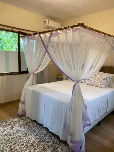 a bedroom with a bed with a canopy at Casa Nice Trancoso in Trancoso
