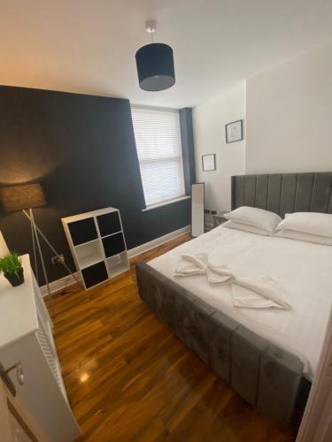 Luxevibe apartment في بلاكبول: غرفة نوم بسرير كبير وجدار ازرق