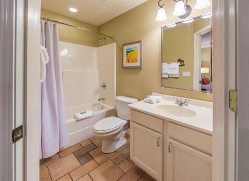 a bathroom with a sink and a toilet and a tub at Holiday Inn Club Vacations Fox River Resort at Sheridan in Sheridan