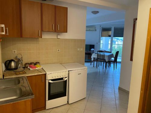 a kitchen with a sink and a stove top oven at Najd apartment in Igalo