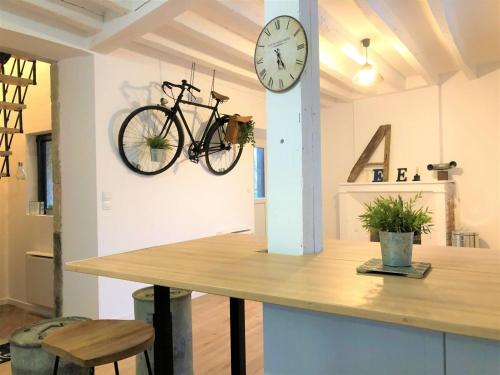 ein Fahrrad, das mit einer Uhr an der Wand hängt in der Unterkunft Caporizon-L'Atelier-Aux portes du chateau de Chambord in Saint-Claude-de-Diray