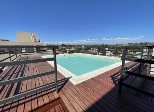 a deck with a swimming pool on top of a building at Paseo Quattro Villa Carlos Paz in Villa Carlos Paz