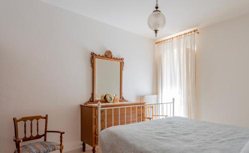 1 dormitorio con espejo, 1 cama y 1 silla en Casa Stanzian, en Gessopalena