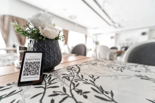 a table with a phone and a vase of flowers at Hotel Santiny in Sveta Nedelja