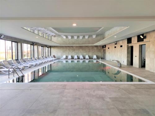 ein Swimmingpool mit Stühlen in einem Gebäude in der Unterkunft Apartament Marina Bay & SPA in Dziwnów