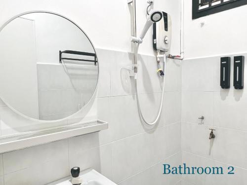 ein Bad mit einem runden Spiegel und einem Waschbecken in der Unterkunft HeySnowy Netflix & gated and guarded & Lotus in Keluang