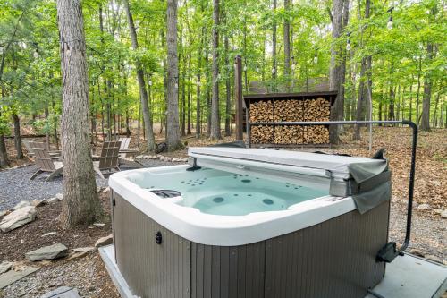 a hot tub in the middle of the woods at Modern Cabin w/Hot Tub & Fire Pit! in Hedgesville